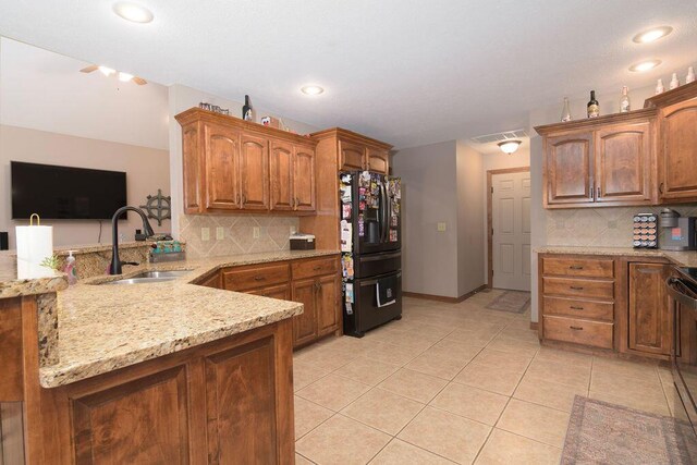 1054 W Itaska Rd, Nixa, MO 65714 - kitchen featuring black refrigerator with ice dispenser, light stone counters, decorative backsplash, a peninsula, and light tile patterned floors