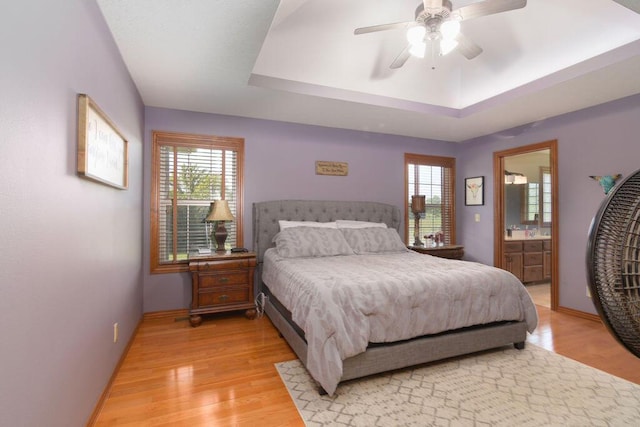 1054 W Itaska Rd, Nixa, MO 65714 - bedroom with a tray ceiling, light wood-type flooring, ensuite bathroom, and a ceiling fan