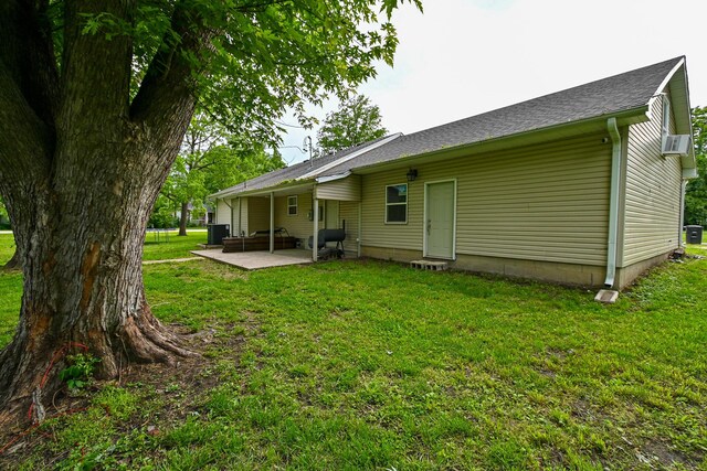 511 C St, Deepwater, MO 64740 - back of property with a patio, a yard, central air condition unit, a shingled roof, and cooling unit