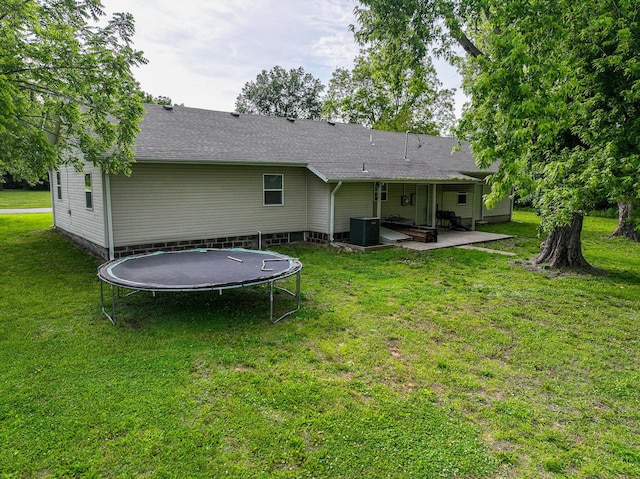 511 C St, Deepwater, MO 64740 - back of property with a trampoline, a patio area, a lawn, and cooling unit