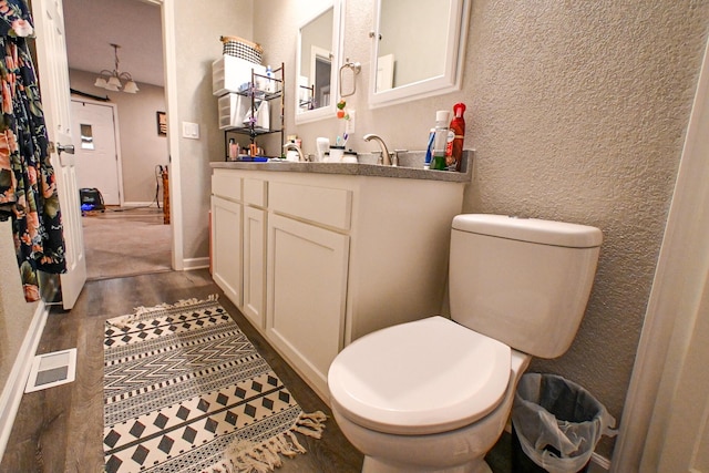 511 C St, Deepwater, MO 64740 - bathroom featuring toilet, wood finished floors, a textured wall, and vanity