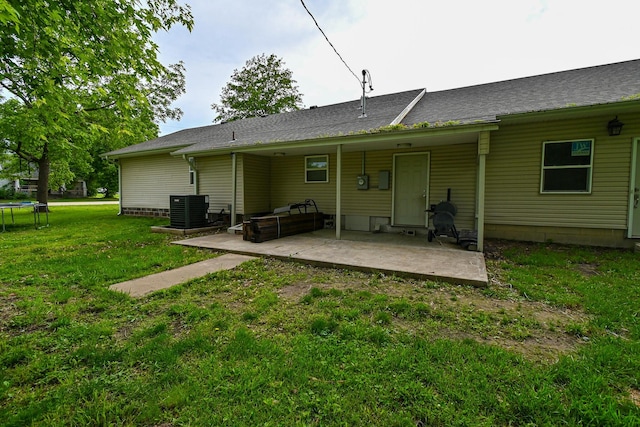 511 C St, Deepwater, MO 64740 - rear view of house featuring a trampoline, a patio area, central AC unit, and a yard