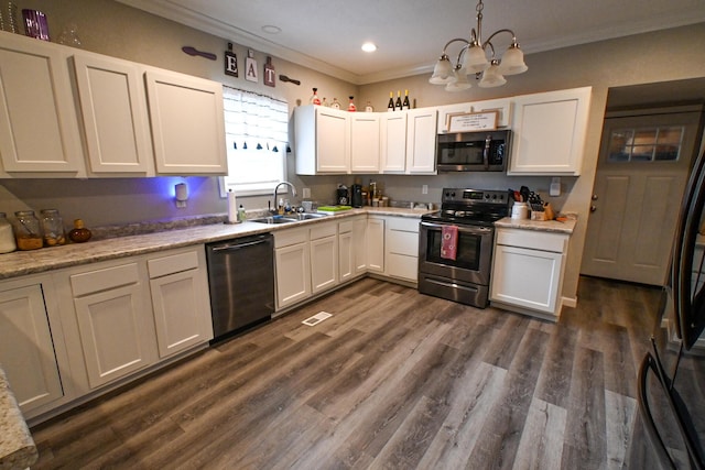511 C St, Deepwater, MO 64740 - kitchen with appliances with stainless steel finishes, a sink, crown molding, a chandelier, and light countertops