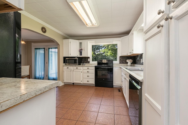 1104 E Buffalo St, Bolivar, MO 65613 - kitchen with black appliances, a sink, backsplash, arched walkways, and light countertops