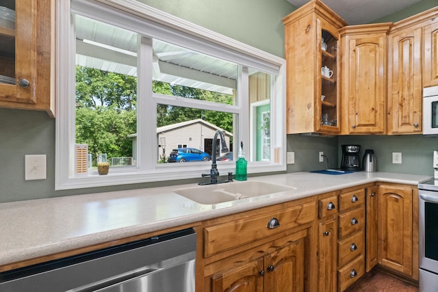 36205 State Highway 413, Crane, MO 65633 - kitchen featuring stainless steel appliances, a sink, glass insert cabinets, light countertops, and brown cabinets