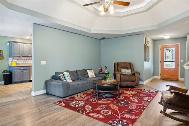 1270 E Ogorman Ct, Springfield, MO 65803 - living area featuring a ceiling fan, light wood-style floors, a raised ceiling, and baseboards