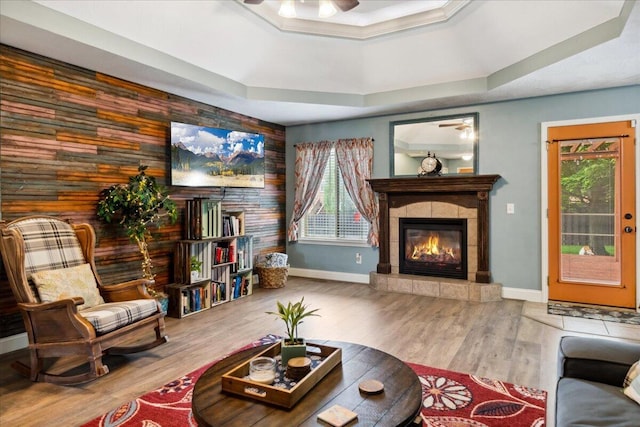1270 E Ogorman Ct, Springfield, MO 65803 - living room featuring ceiling fan, a tray ceiling, plenty of natural light, wooden walls, and a tiled fireplace