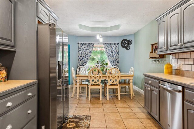 1270 E Ogorman Ct, Springfield, MO 65803 - kitchen featuring stainless steel appliances, baseboards, light countertops, decorative backsplash, and a textured ceiling
