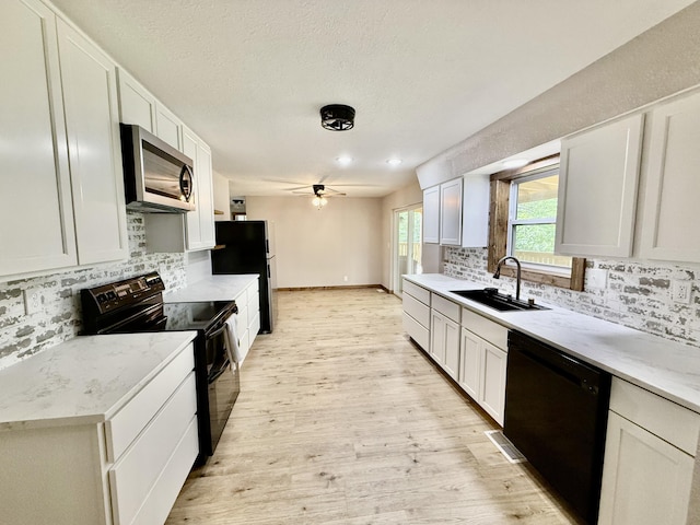 8030 Indiana Dr, Houston, MO 65483 - kitchen featuring black appliances, a sink, ceiling fan, tasteful backsplash, and light wood-type flooring