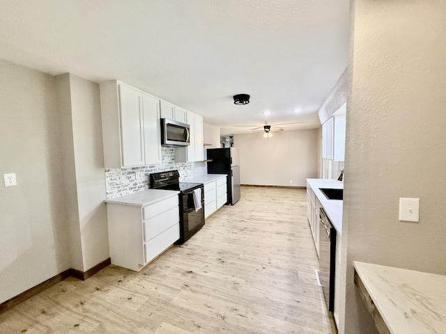 8030 Indiana Dr, Houston, MO 65483 - kitchen with appliances with stainless steel finishes, light wood-style floors, tasteful backsplash, white cabinetry, and light countertops