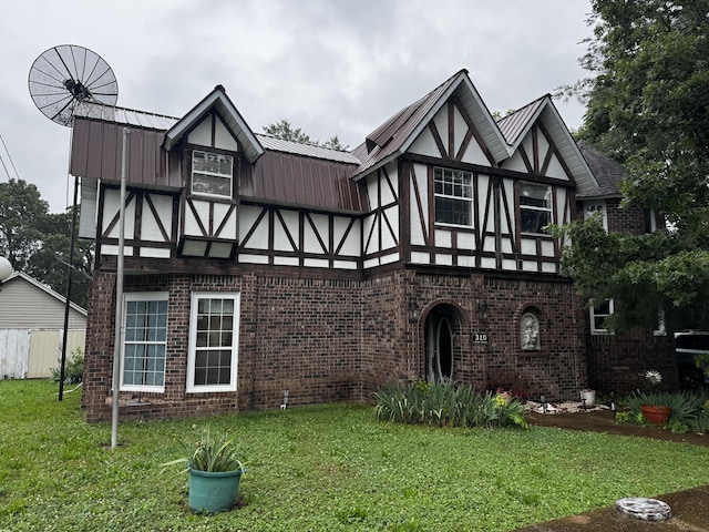 310 S 6th St, Thayer, MO 65791 - english style home featuring brick siding, a front lawn, metal roof, and stucco siding