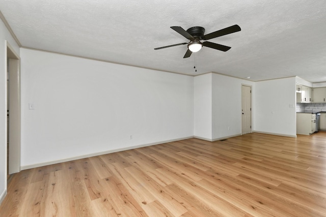 2658 S Hillsboro, Springfield, MO 65802 - unfurnished living room with light wood finished floors, a textured ceiling, ceiling fan, and baseboards