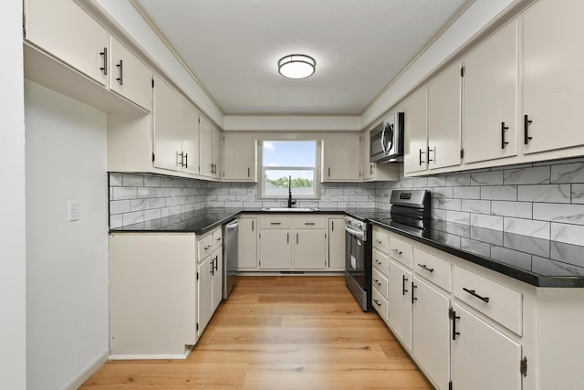 2658 S Hillsboro, Springfield, MO 65802 - kitchen with stainless steel appliances, dark countertops, light wood finished floors, and decorative backsplash