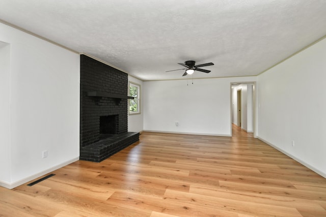 2658 S Hillsboro, Springfield, MO 65802 - unfurnished living room with ceiling fan, a brick fireplace, light wood-style floors, baseboards, and a textured ceiling