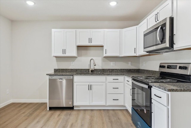 1052 S Overhill Ave, Springfield, MO 65802 - kitchen featuring stainless steel appliances, a sink, light wood-style flooring, white cabinets, and recessed lighting