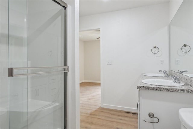 1052 S Overhill Ave, Springfield, MO 65802 - full bathroom featuring wood finished floors, double vanity, a stall shower, baseboards, and toilet