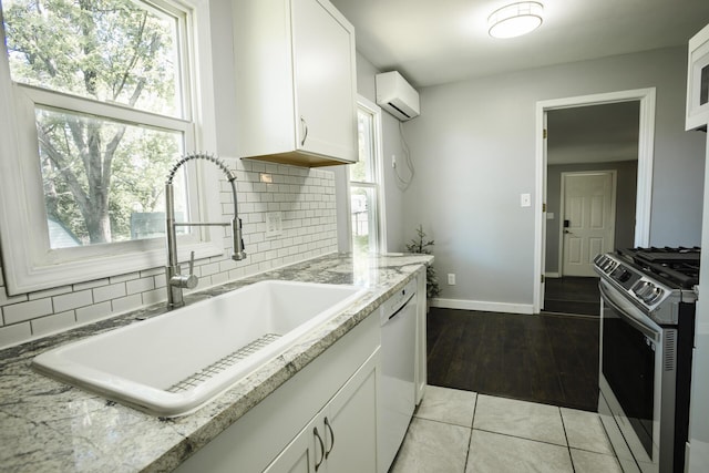 1443 6th St, West Plains, MO 65775 - kitchen with white appliances, a sink, a wall mounted air conditioner, white cabinets, and tasteful backsplash