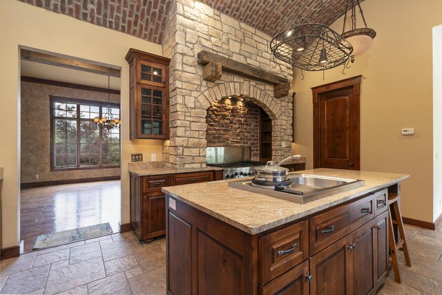 184 Appaloosa Trl, Saddlebrooke, MO 65630 - kitchen with stone tile flooring, baseboards, brick ceiling, glass insert cabinets, and pendant lighting