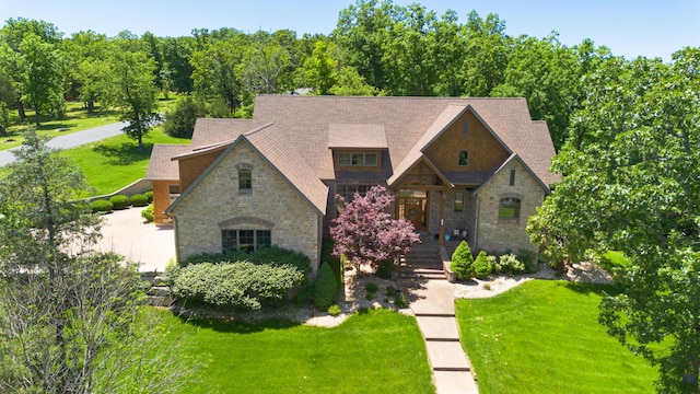 184 Appaloosa Trl, Saddlebrooke, MO 65630 - view of front facade with stone siding, a front yard, covered porch, and roof with shingles
