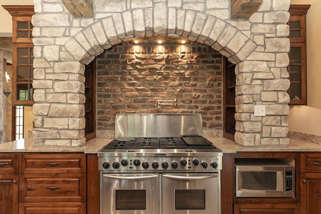184 Appaloosa Trl, Saddlebrooke, MO 65630 - kitchen with appliances with stainless steel finishes, light stone counters, and glass insert cabinets