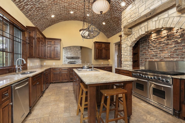 184 Appaloosa Trl, Saddlebrooke, MO 65630 - kitchen featuring stainless steel appliances, a sink, stone tile floors, vaulted ceiling, and a center island with sink