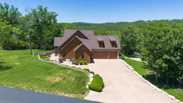 184 Appaloosa Trl, Saddlebrooke, MO 65630 - view of front facade with a garage, concrete driveway, a wooded view, and a front lawn