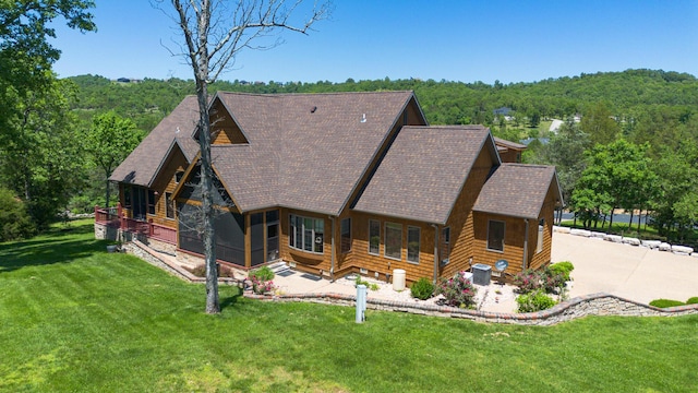 184 Appaloosa Trl, Saddlebrooke, MO 65630 - back of house with roof with shingles, a wooded view, and a lawn
