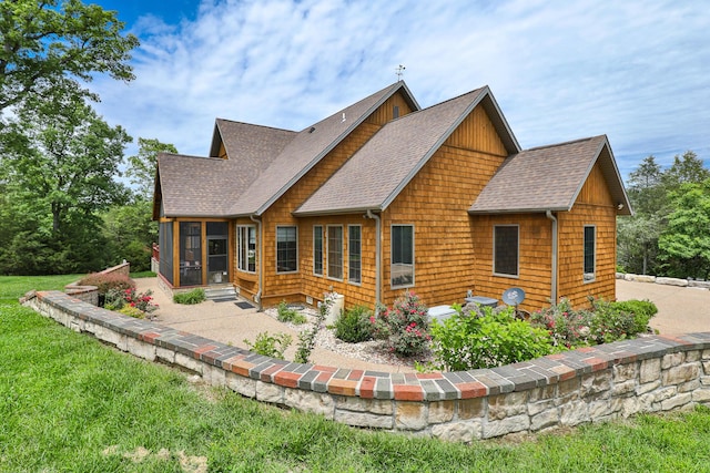 184 Appaloosa Trl, Saddlebrooke, MO 65630 - rear view of house featuring a shingled roof, a sunroom, and a patio area