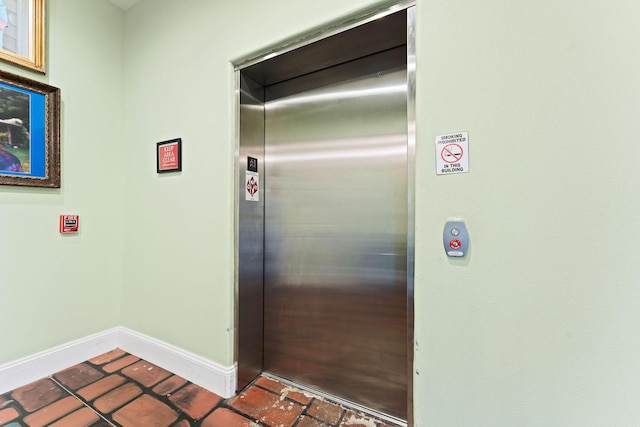 180 Grace Chapel Rd, Blue Eye, MO 65611 - hallway featuring elevator, baseboards, and brick flooring