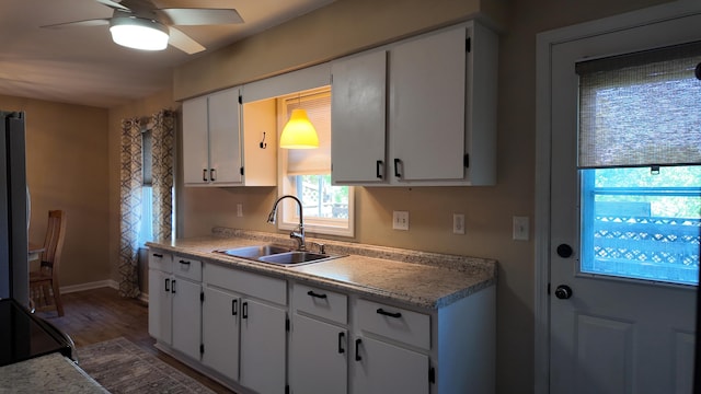 606 W Clover Dr, Clinton, MO 64735 - kitchen featuring a sink, ceiling fan, light countertops, white cabinetry, and wood finished floors