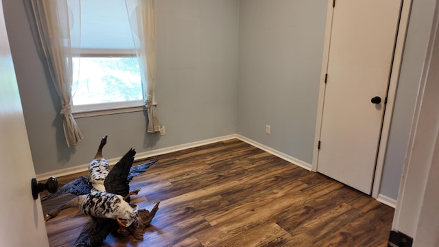 606 W Clover Dr, Clinton, MO 64735 - unfurnished bedroom with dark wood-type flooring and baseboards