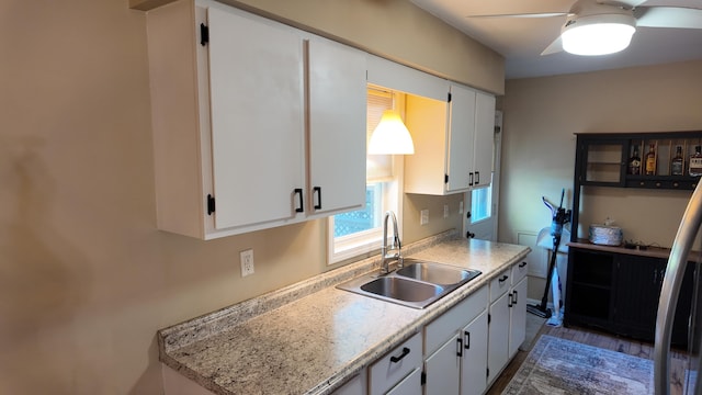 606 W Clover Dr, Clinton, MO 64735 - kitchen featuring a sink, ceiling fan, light countertops, and white cabinetry