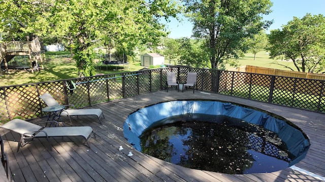 606 W Clover Dr, Clinton, MO 64735 - wooden deck featuring a trampoline, an empty pool, and view of scattered trees