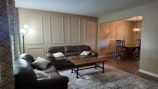 606 W Clover Dr, Clinton, MO 64735 - living area featuring wood finished floors, a chandelier, and baseboards