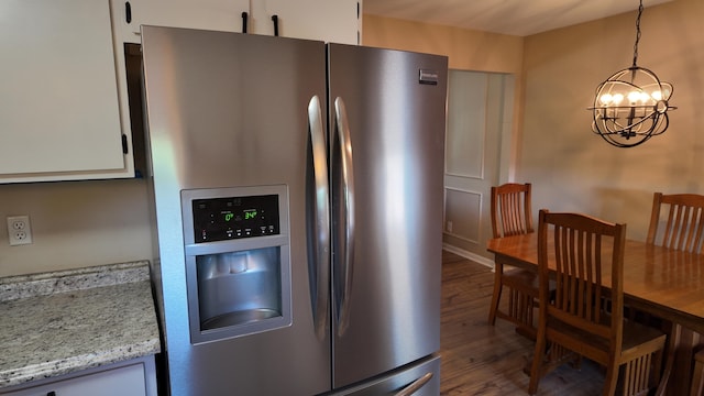 606 W Clover Dr, Clinton, MO 64735 - kitchen with stainless steel fridge, a chandelier, wood finished floors, white cabinetry, and hanging light fixtures
