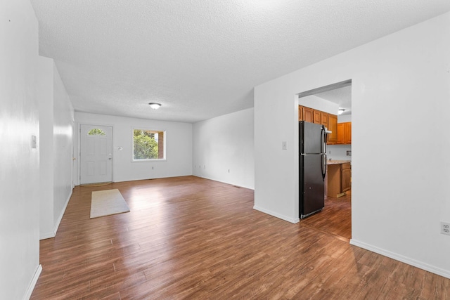 111-141 Gooseberry Ct, Branson, MO 65616 - unfurnished living room featuring wood finished floors, a textured ceiling, and baseboards