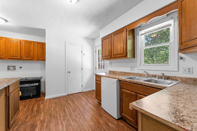 111-141 Gooseberry Ct, Branson, MO 65616 - kitchen featuring a sink, dishwashing machine, brown cabinetry, dark wood-type flooring, and healthy amount of natural light