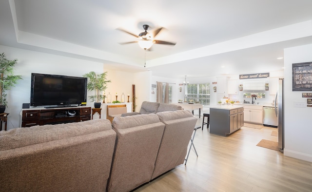 205 Seigenbein Rd, Saint Robert, MO 65584 - living room featuring a ceiling fan, a tray ceiling, light wood-style floors, and baseboards