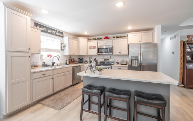 205 Seigenbein Rd, Saint Robert, MO 65584 - kitchen featuring stainless steel appliances, a sink, a breakfast bar, light countertops, and recessed lighting