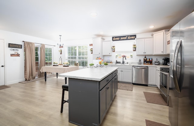 205 Seigenbein Rd, Saint Robert, MO 65584 - kitchen with appliances with stainless steel finishes, light countertops, a breakfast bar, light wood-type flooring, and recessed lighting