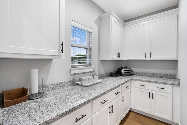 1816 N Bristol Ave, Springfield, MO 65802 - kitchen with white cabinetry, light stone counters, and wood finished floors