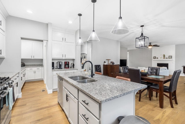 1816 N Bristol Ave, Springfield, MO 65802 - kitchen with a sink, a large fireplace, light wood-style flooring, appliances with stainless steel finishes, and recessed lighting