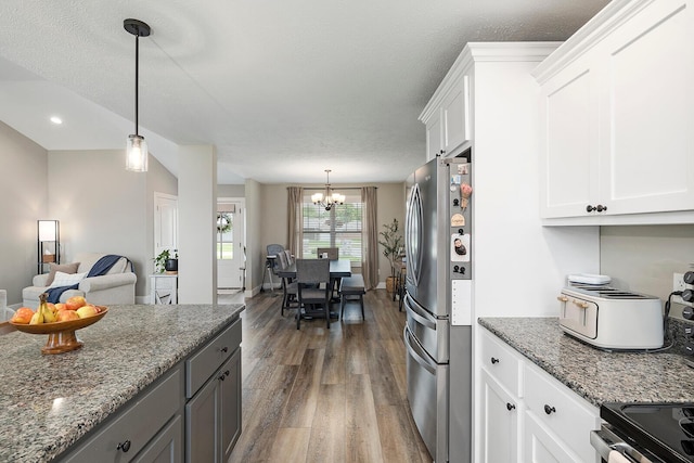 2025 Diego Ct, Bolivar, MO 65613 - kitchen with appliances with stainless steel finishes, dark wood-style floors, a chandelier, white cabinetry, and light stone counters