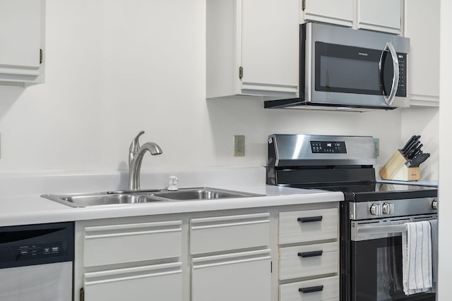 128 Bunker Ridge Rd Unit 2, Branson, MO 65616 - kitchen featuring stainless steel appliances, a sink, light countertops, and white cabinetry