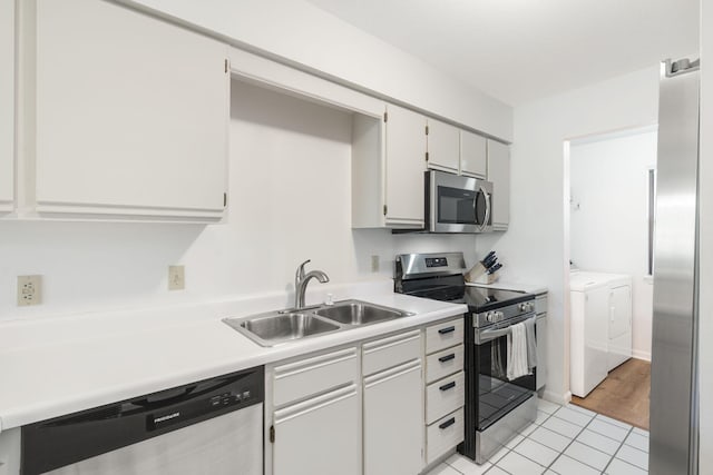 128 Bunker Ridge Rd Unit 2, Branson, MO 65616 - kitchen with appliances with stainless steel finishes, washing machine and clothes dryer, a sink, light tile patterned floors, and light countertops