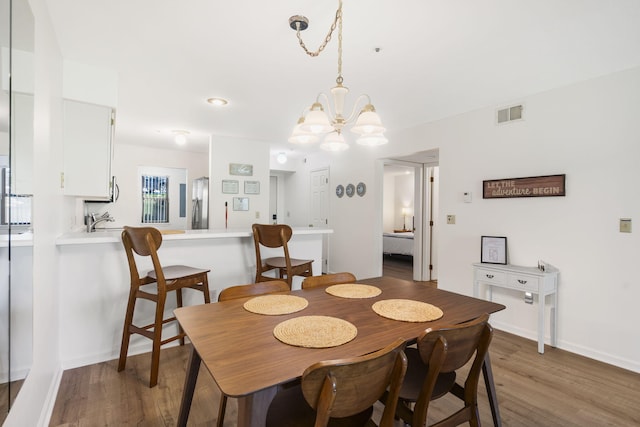 128 Bunker Ridge Rd Unit 2, Branson, MO 65616 - dining space featuring a chandelier, wood finished floors, and baseboards