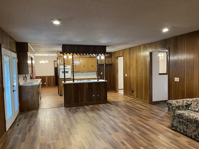 641 N Claud Ave, Bolivar, MO 65613 - kitchen featuring oven, a textured ceiling, wood finished floors, light countertops, and a kitchen island