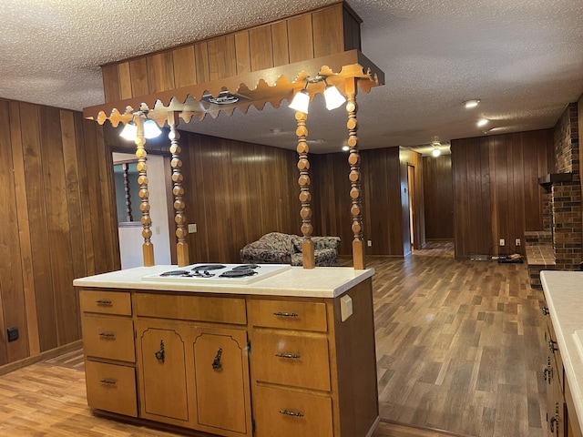 641 N Claud Ave, Bolivar, MO 65613 - kitchen with a textured ceiling, wood walls, light wood-style flooring, light countertops, and white electric stovetop