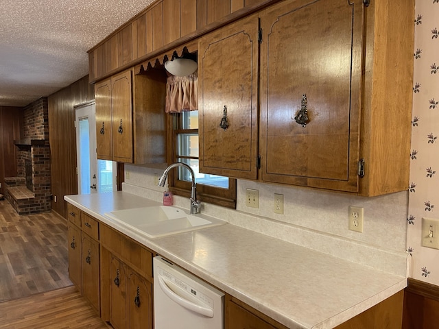 641 N Claud Ave, Bolivar, MO 65613 - kitchen featuring dishwasher, a sink, a textured ceiling, wood finished floors, and brown cabinets