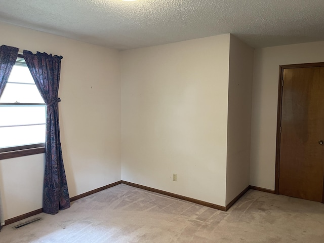 641 N Claud Ave, Bolivar, MO 65613 - unfurnished room featuring light carpet, baseboards, and a textured ceiling